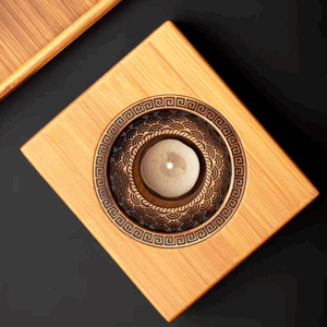 Elegant bamboo teapot warmer with handmade ceramic teapot, candle holder, and trivet perfect for home tea brewing. 